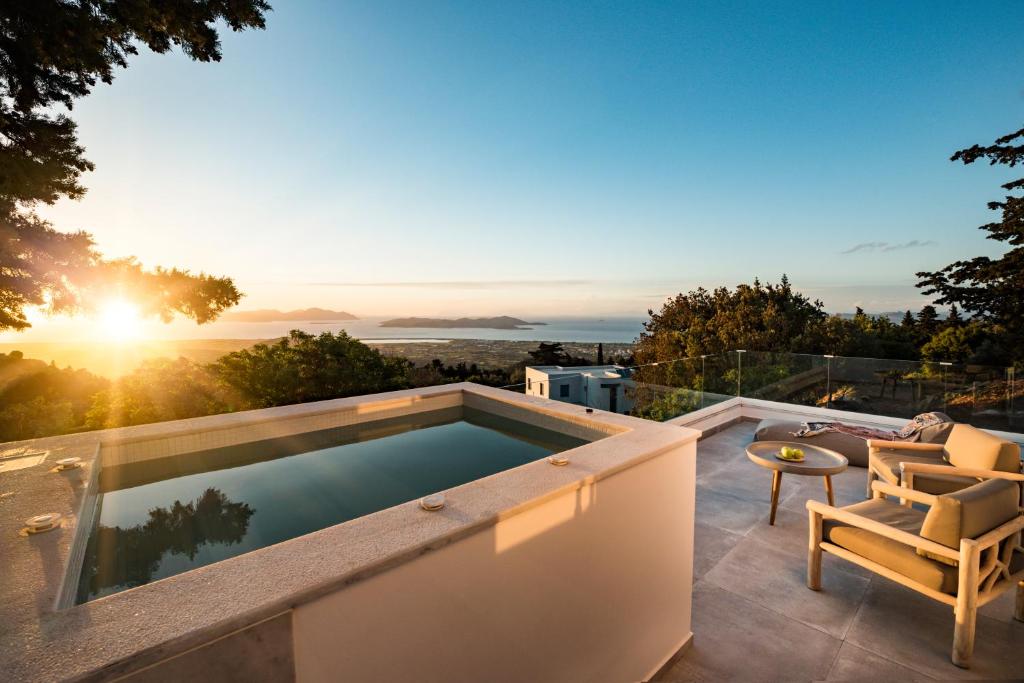 uma piscina no telhado de uma casa com o pôr do sol em Forest View Villas 1 em Lagoúdi Zía