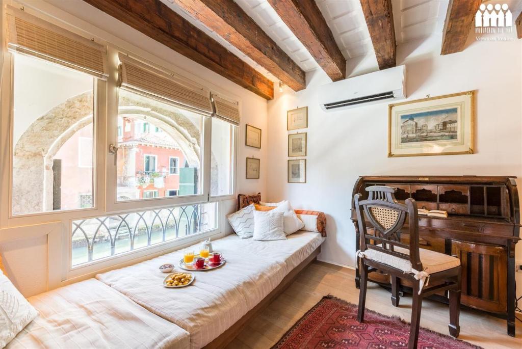 een woonkamer met een bank en een raam bij Ca' Tintoretto Canal View in Venetië
