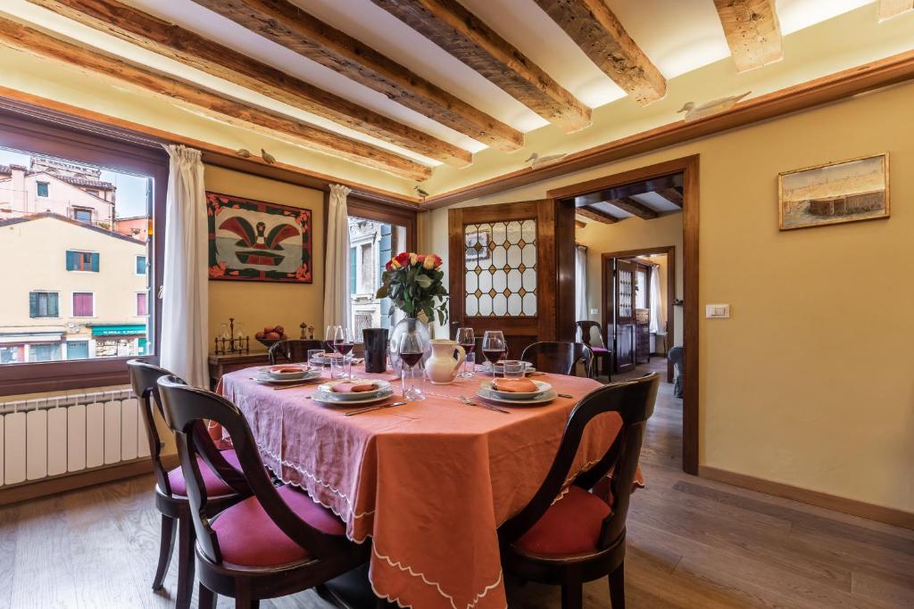 a dining room with a table and chairs at La Tana Cozy Apartment in Campo San Maurizio in Venice