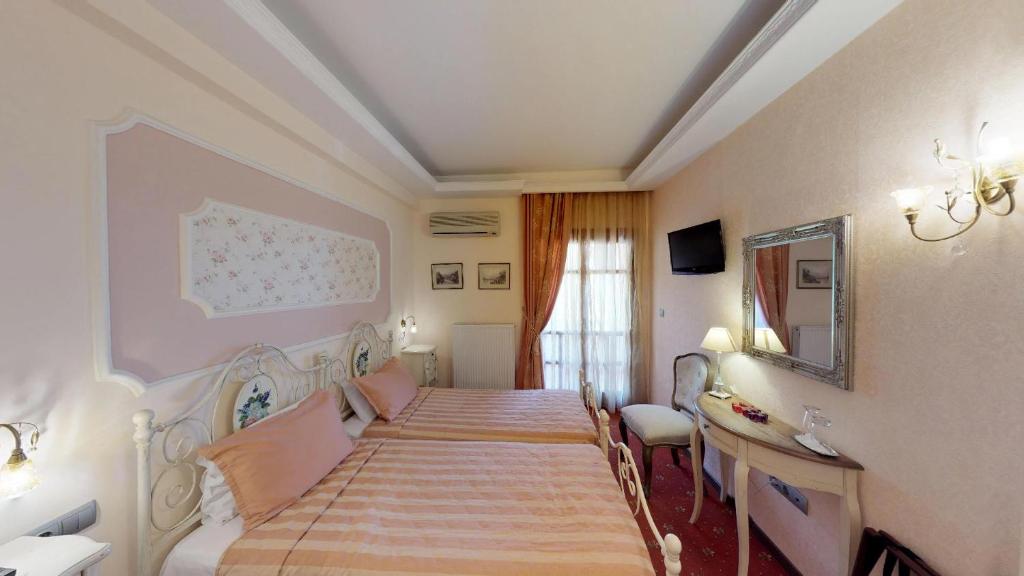 a bedroom with two beds and a mirror at Hotel Mirto in Litochoro
