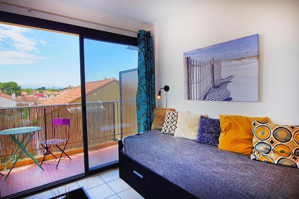 a living room with a couch and a balcony at Studio moderne à la plage in Canet-en-Roussillon