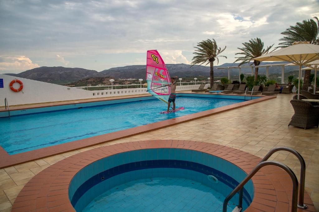 a person holding a sail in a swimming pool at Castri Village Hotel in Palekastron