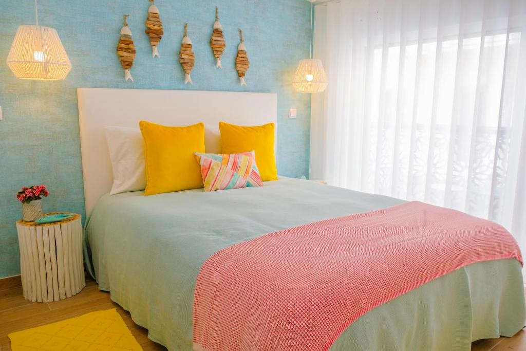una camera da letto con un grande letto con cuscini colorati di Iris Apartment - Home Dream a Nazaré