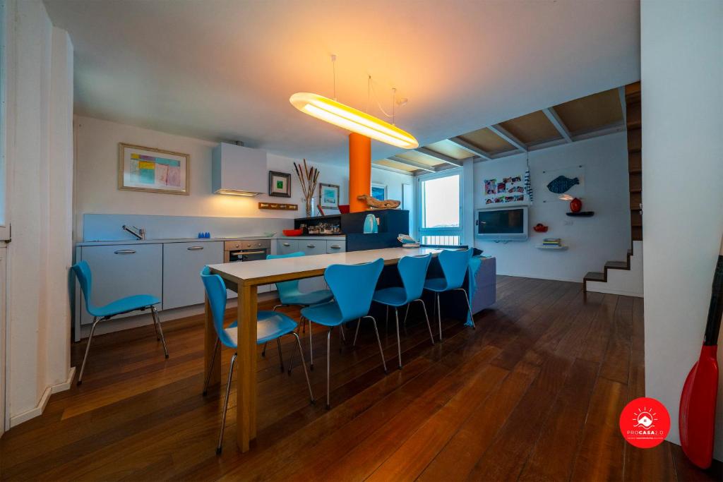 una cucina e una sala da pranzo con tavolo e sedie blu di La casa dagli occhi blu a Portovenere