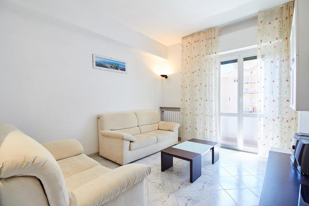ein Wohnzimmer mit einem Sofa und einem Tisch in der Unterkunft Via Brunenghi 63 in Finale Ligure