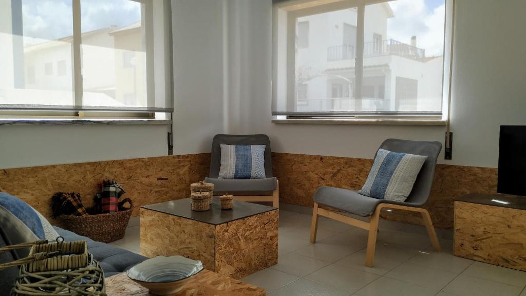 sala de estar con 2 sillas y mesa de centro en Sun House - Baleal, en Ferrel