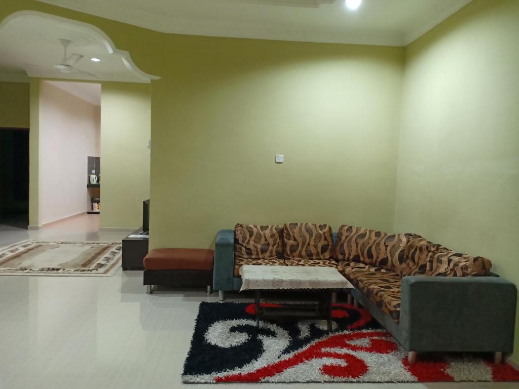 a living room with a couch and a rug at HR Iman Homestay in Dungun