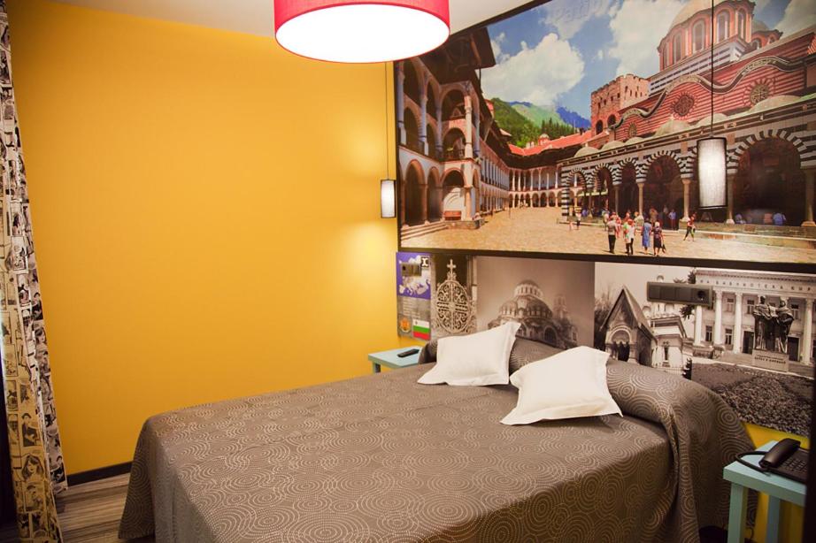 a bedroom with a bed with a painting on the wall at JC Rooms Santo Domingo in Madrid