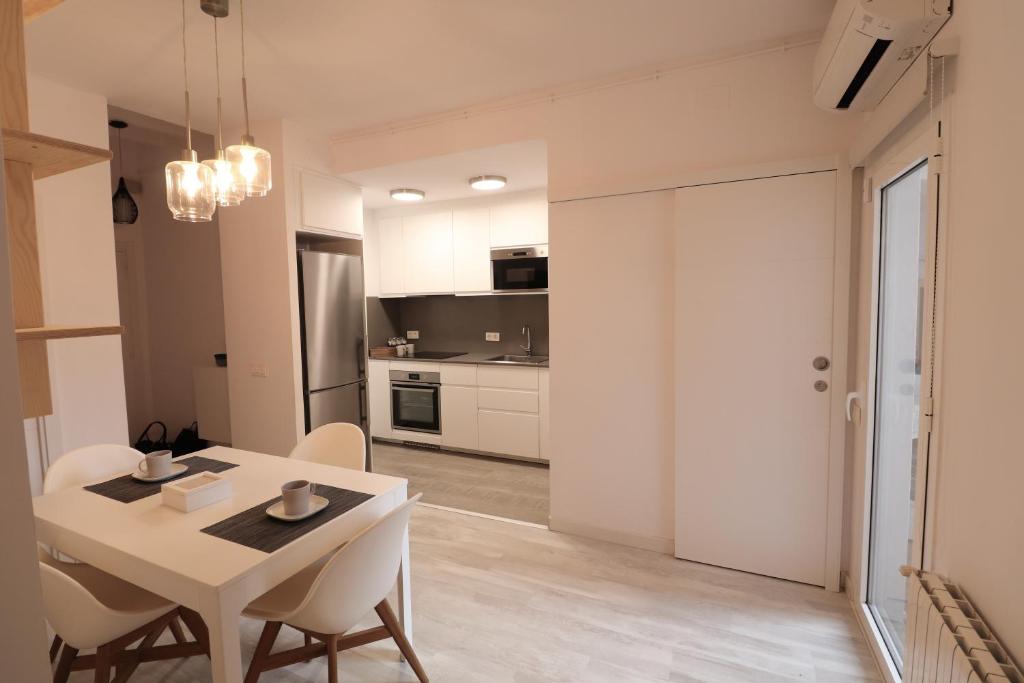 cocina y comedor con mesa y sillas en Cool Apartment - Parc Migdia - Center Girona, en Girona