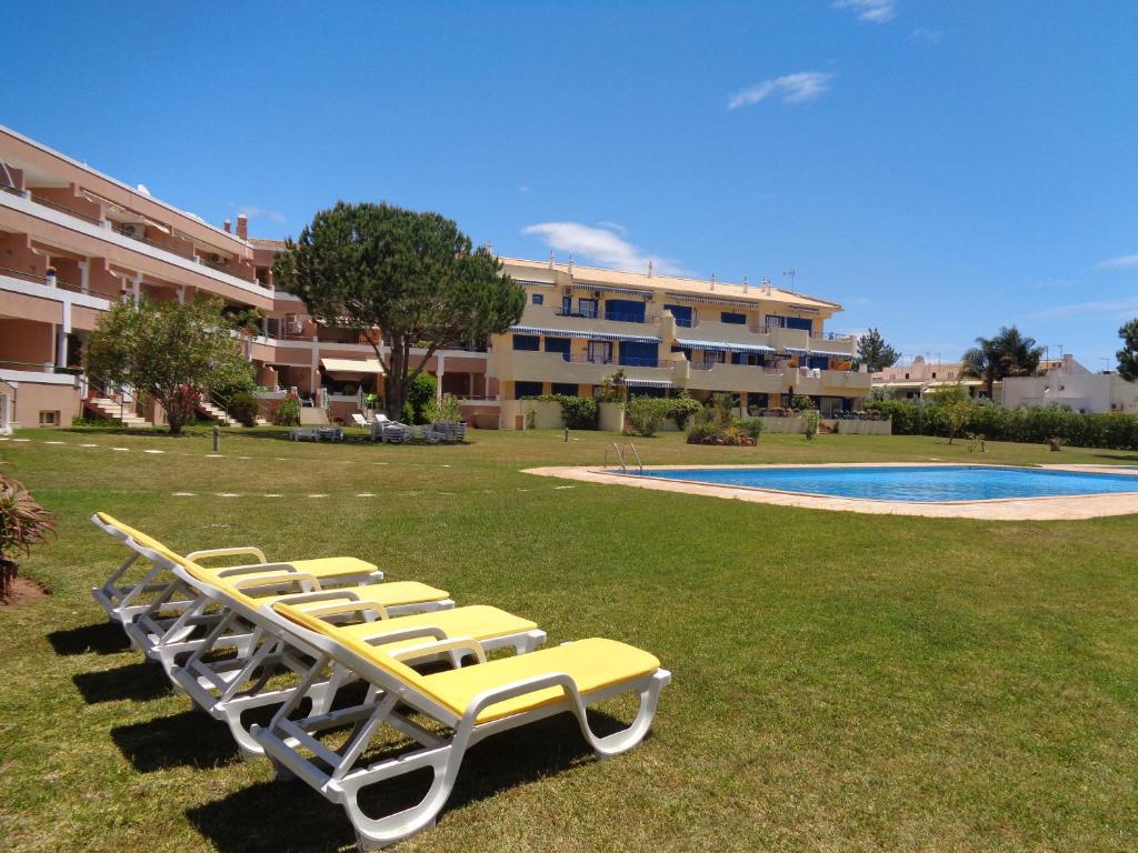 a row of lounge chairs next to a swimming pool at Apartamento Citimar in Vilamoura