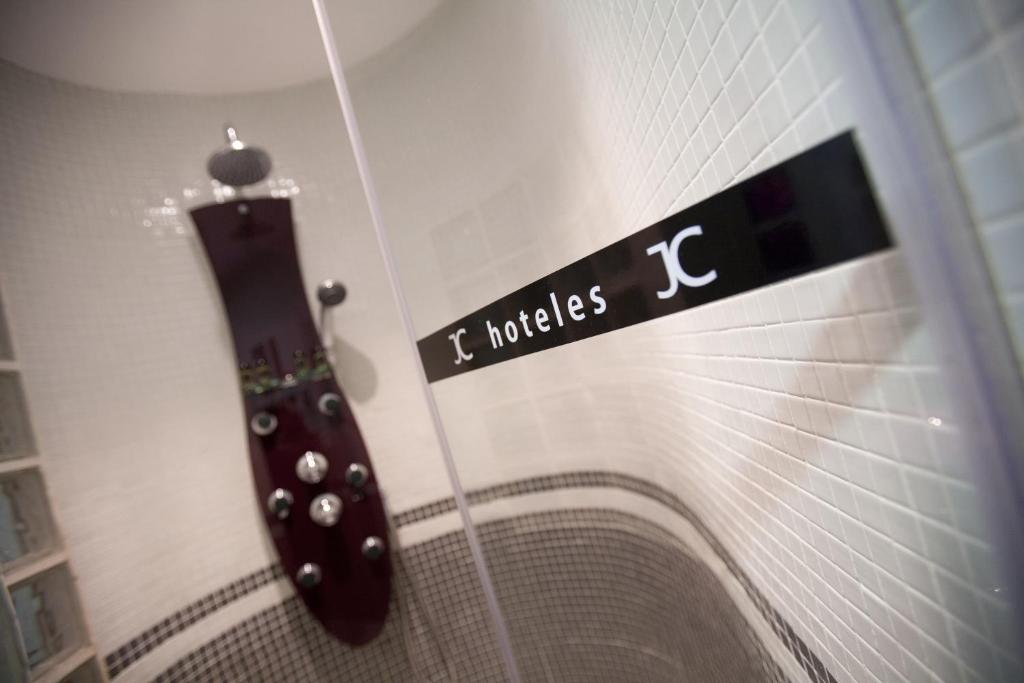 a bathroom with a black guitar on the wall at JC Rooms Santo Domingo in Madrid
