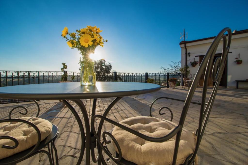 uma mesa e cadeiras com um vaso de flores em Samareitidos Light Cottage em Anaphotia