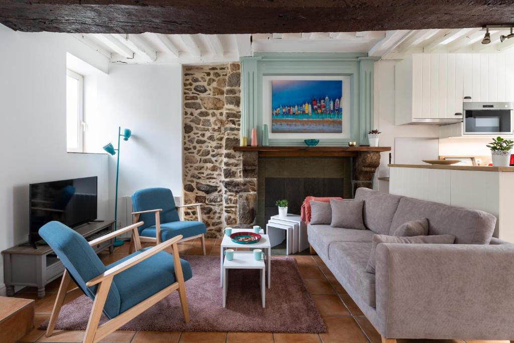 - un salon avec un canapé et une cheminée dans l'établissement Le Doris by Cocoonr, à Saint-Malo