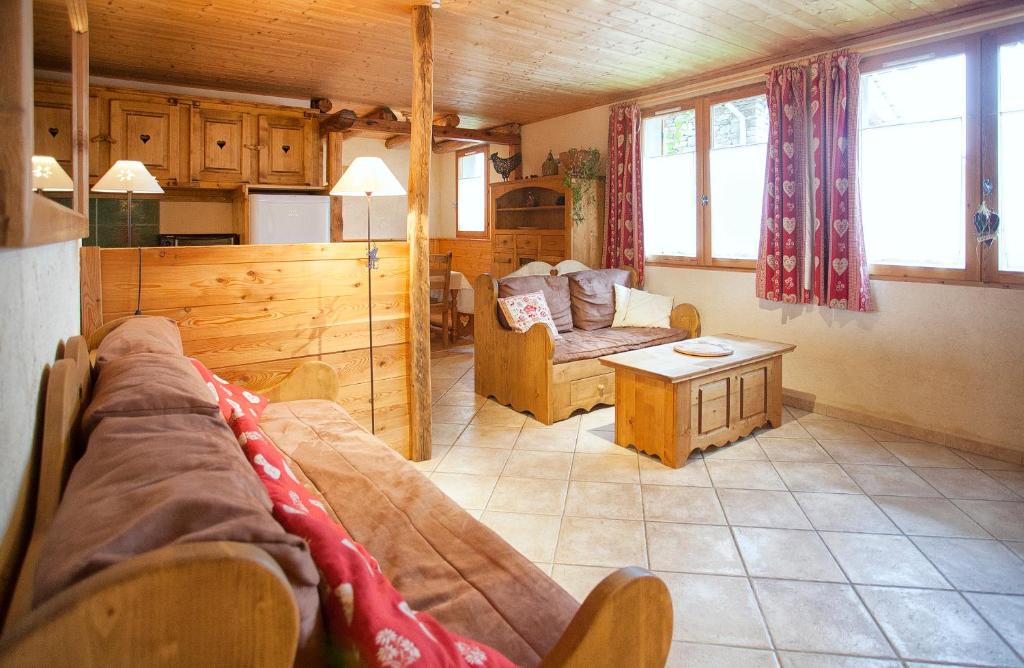 ein Wohnzimmer mit einem Sofa und einem Tisch in der Unterkunft Chalet la Lauzette in Bessans