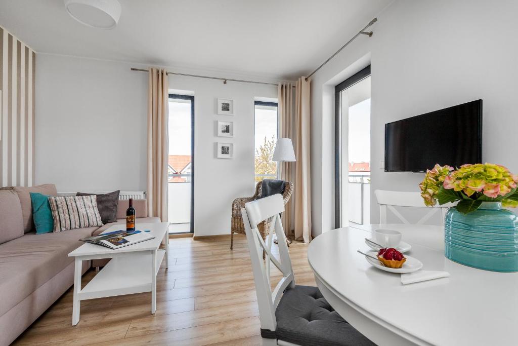 ein Wohnzimmer mit einem Sofa und einem Tisch in der Unterkunft Apartament Konik Morski - Apartamenty Vento in Władysławowo