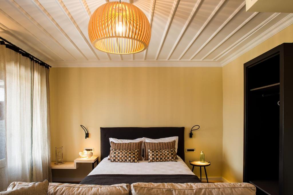 a bedroom with a large bed and a ceiling at Aethra Boutique Rooms in Nafplio