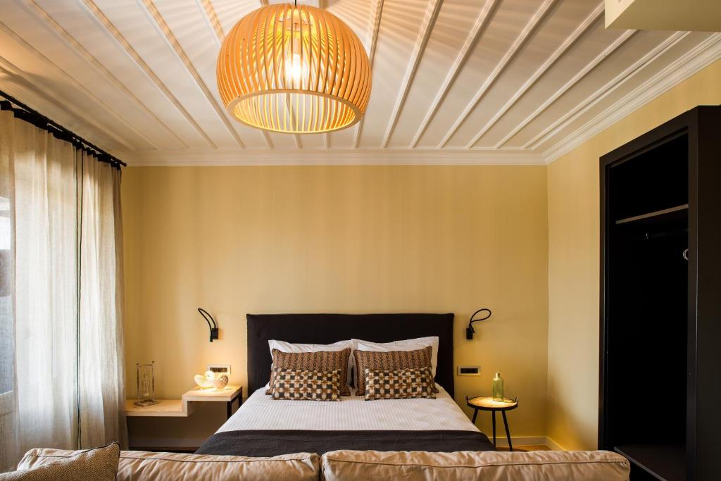 una camera con un grande letto e un soffitto di Aethra Boutique Rooms a Nauplia