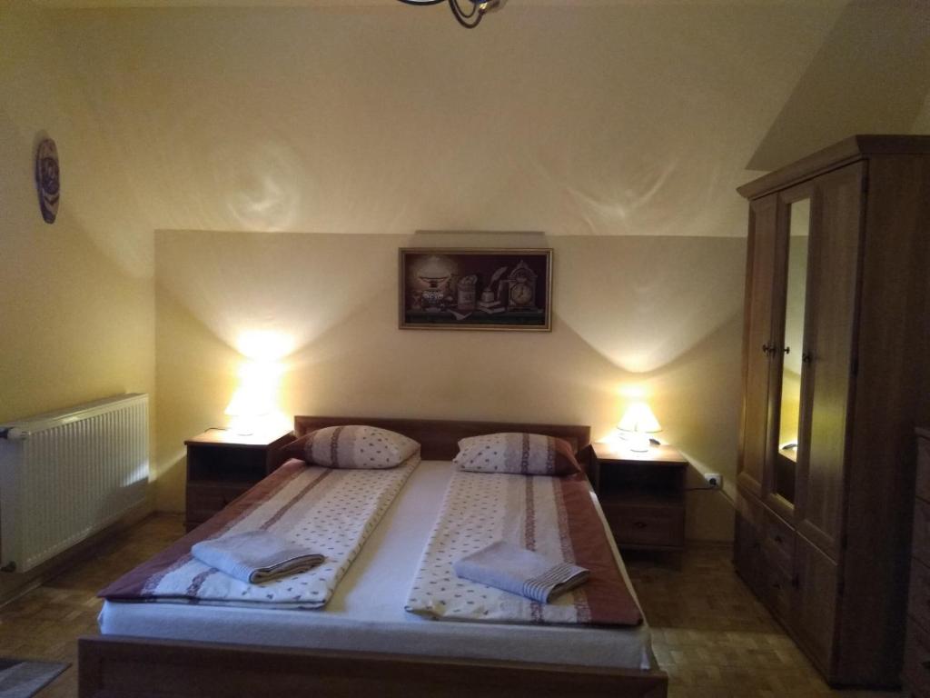 a bedroom with a large bed with two lamps at Lesna 26 in Kudowa-Zdrój