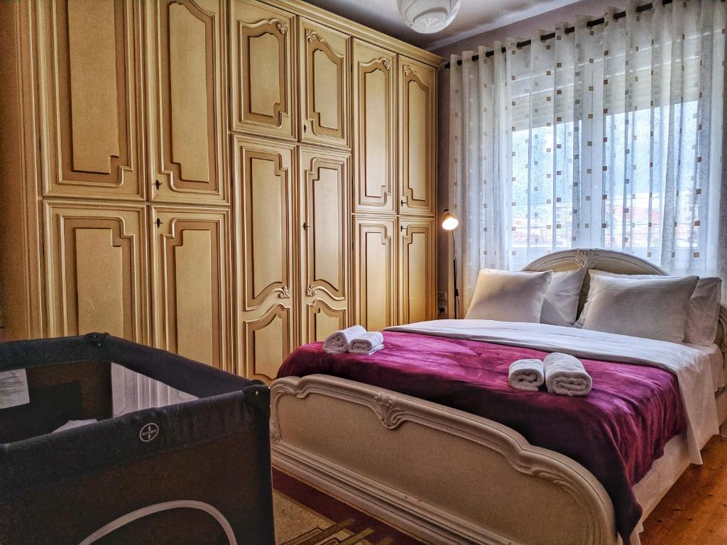 a bedroom with a bed with towels on it at All Seasons Apartments in Shkodër