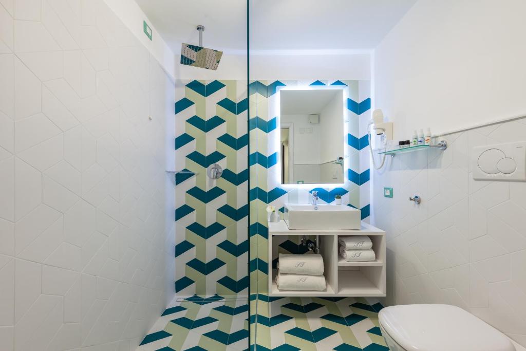a bathroom with a toilet and a sink and a mirror at Sorrento Flats in Sorrento