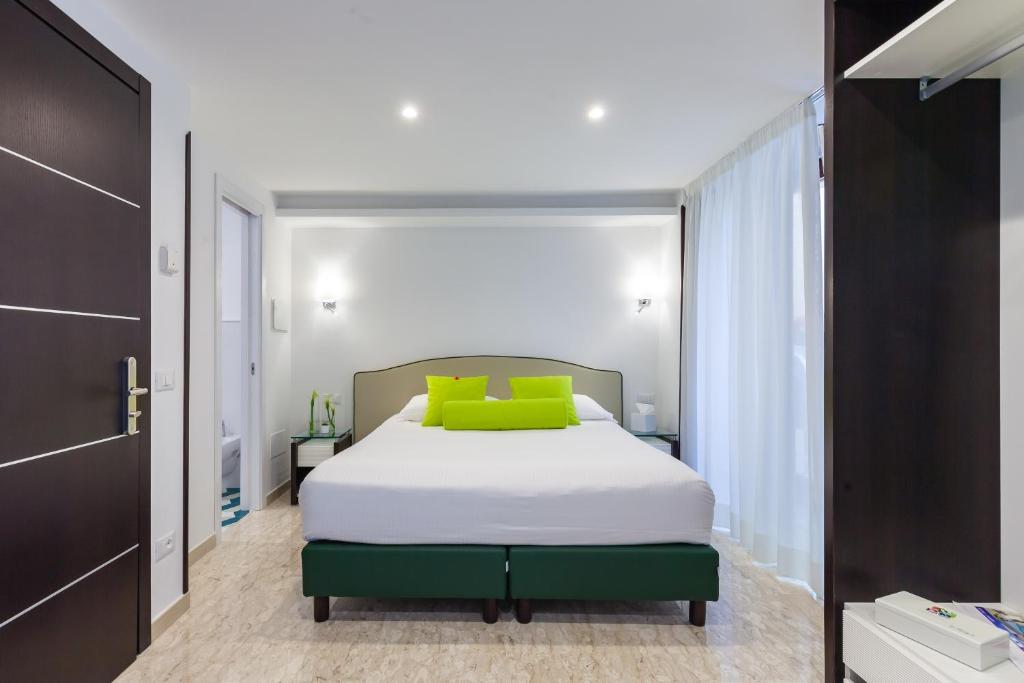 a bedroom with a white bed with green pillows at Sorrento Flats in Sorrento