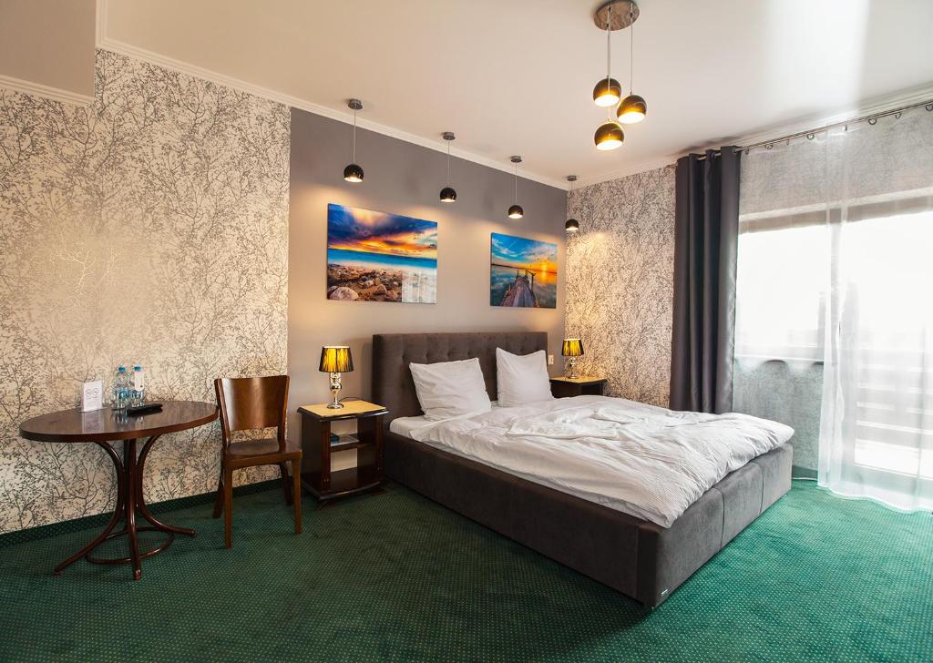 um quarto com uma cama, uma mesa e uma secretária em Hotel Fox em Wolbórz