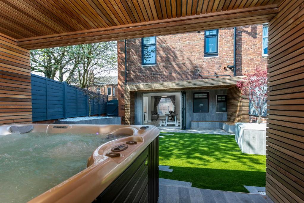 una bañera de hidromasaje en el patio trasero de una casa en The Alexander - Donnini Deluxe en Prestwick
