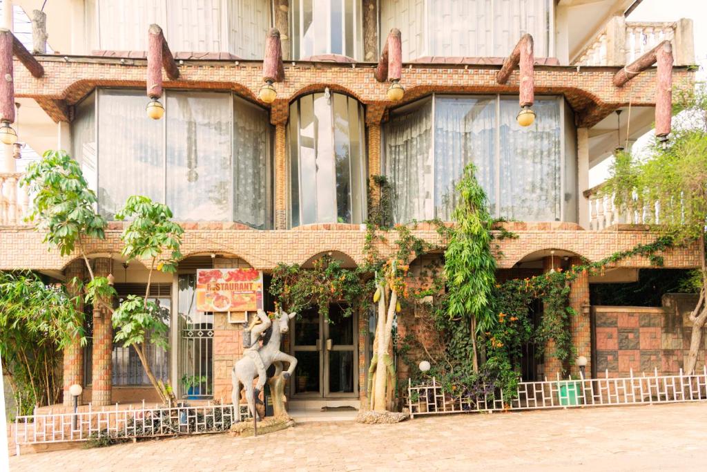 Meliva Guest House Mbarara في Mbarara: مبنى امامه تمثال