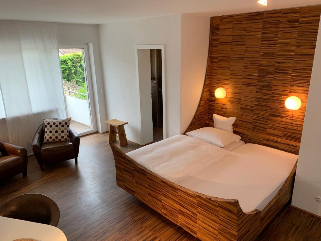 ein Schlafzimmer mit einem großen Bett und einem Stuhl in der Unterkunft hotelmärchen Garni in Ludwigsburg