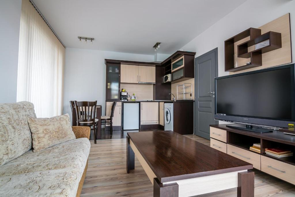 a living room with a couch and a tv at Cozy One-bedroom Apartment in Night Breeze in Burgas