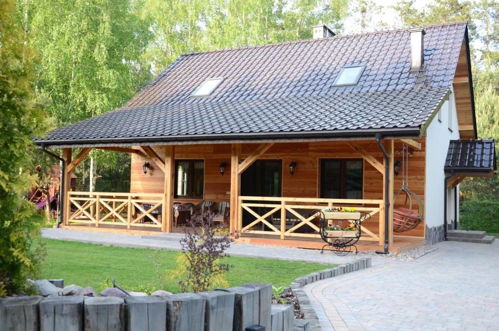 a log cabin with a porch and a patio at Uroczysko Lubiaszów in Nowy Lubiaszów