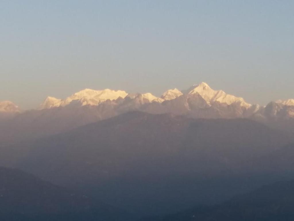 een uitzicht op een bergketen met besneeuwde bergen bij VAMOOSE CHAMLING in Pedong