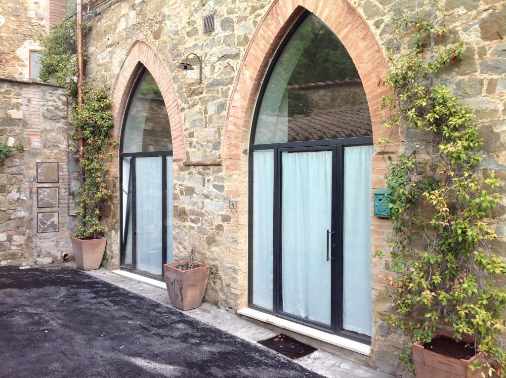 two arched doors on a stone building with potted plants at Montalcino Loft in Montalcino