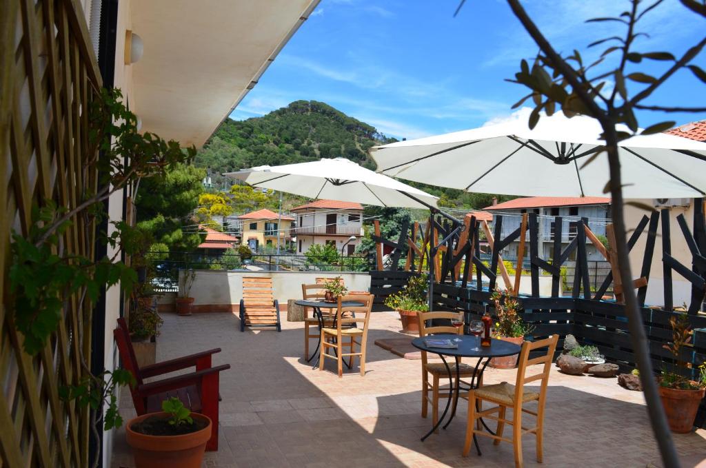 un patio avec des tables, des chaises et des parasols dans l'établissement Gea Apartment Etna, à Nicolosi
