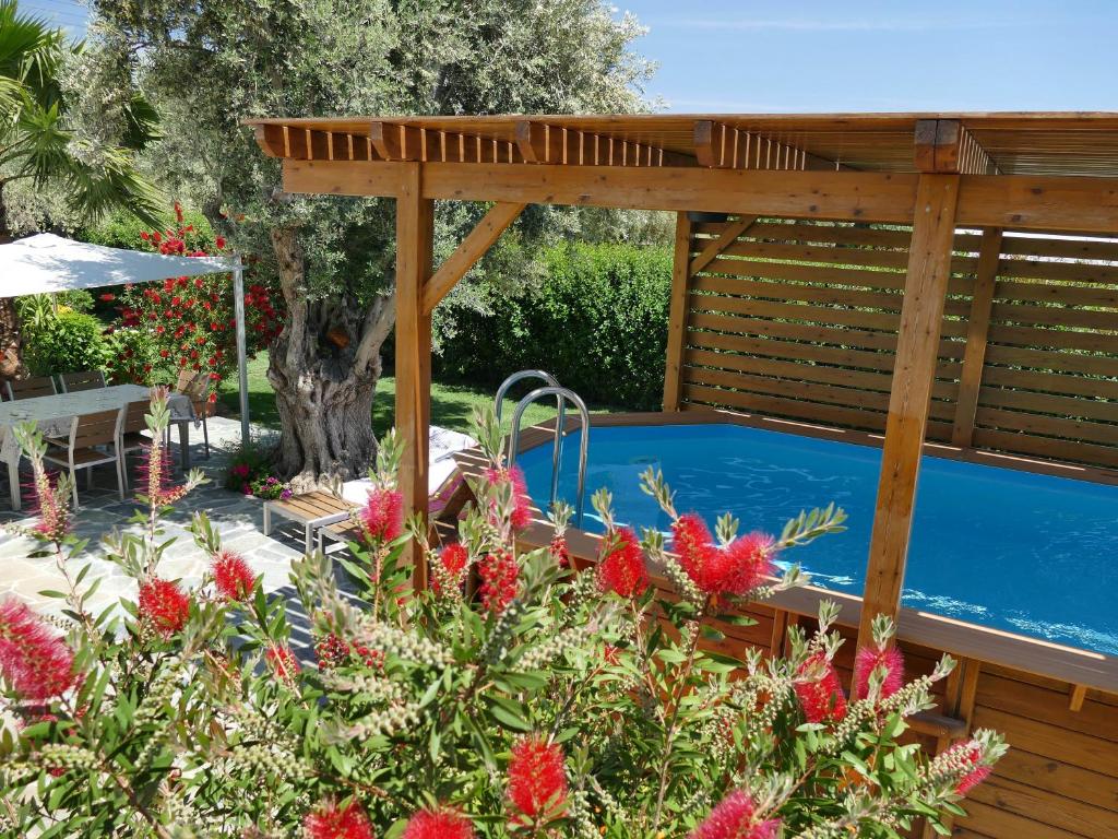 een pergola en een zwembad in de tuin bij Esperides in Marathón