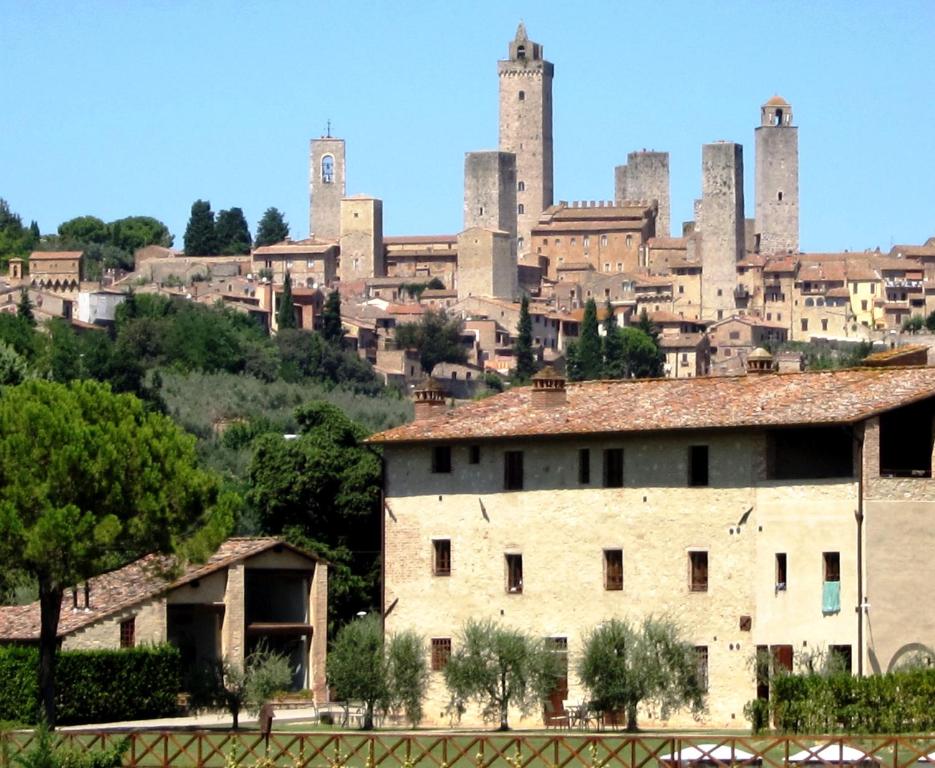 vista su una città con un castello di Fattoria Abbazia Monte Oliveto a San Gimignano