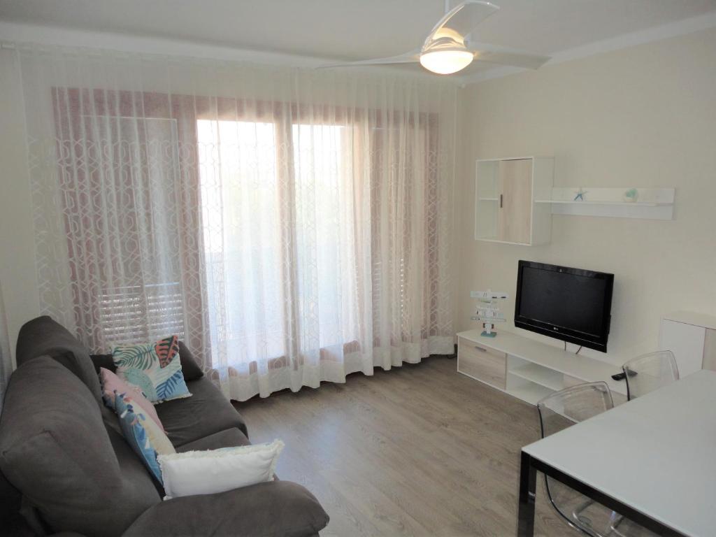 ein Wohnzimmer mit einem Sofa und einem Flachbild-TV in der Unterkunft Lamoga-Sandi 4 2 in Torredembarra