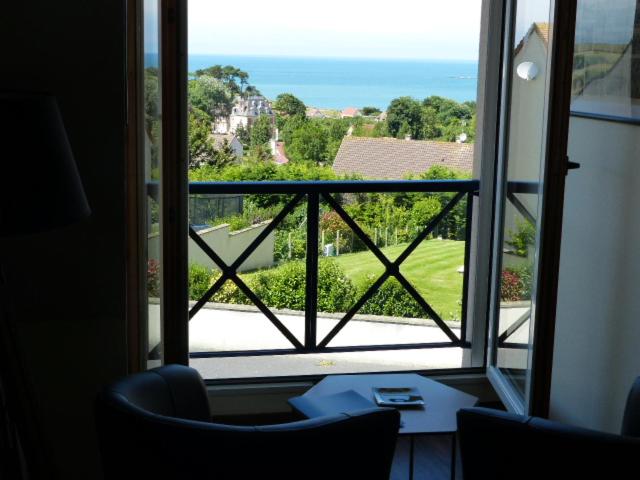Cette chambre dispose d'une fenêtre donnant sur un jardin. dans l'établissement LE RUBAN BLEU FACE A LA MER, à Arromanches-les-Bains