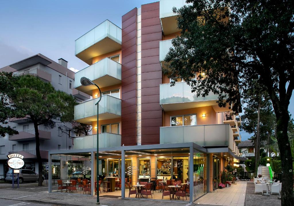 um edifício com mesas e cadeiras em frente em Hotel Daniele em Lignano Sabbiadoro