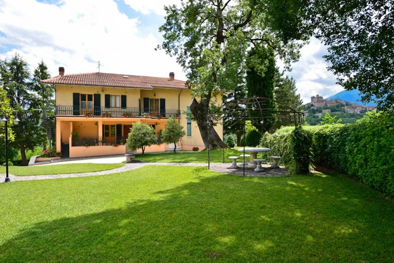 a large house with a yard with a green lawn at Residence Verde Quiete in Sarnano