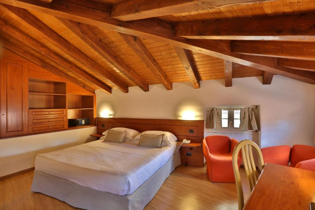 1 dormitorio con 1 cama, mesa y sillas en Hotel James Joyce, en Trieste