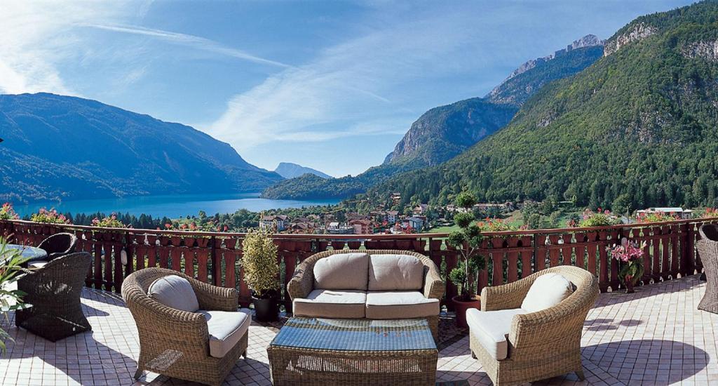 a balcony with chairs and a view of a lake at Hotel Olympia in Molveno