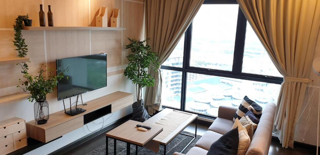 a living room with a tv and a large window at V residence suite 2-4 pax - mrt-wifi-link mall 吉隆玻双威伟乐高级公寓 in Kuala Lumpur