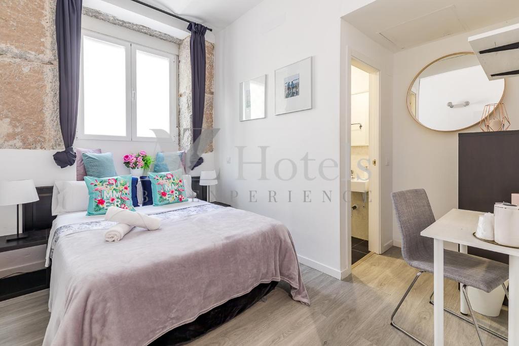 1 dormitorio con cama, mesa y espejo en AYZ Juan de Mena - Auto check-in property, en Madrid