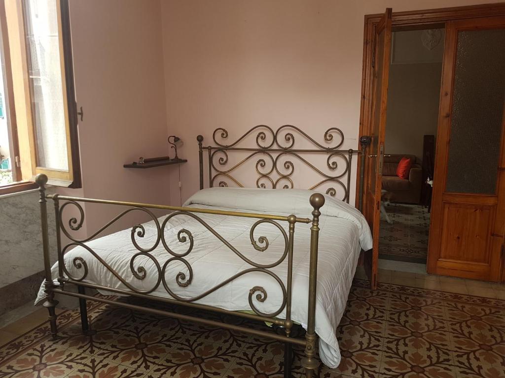 a bedroom with a metal bed with white sheets at Casa Brunello in La Spezia