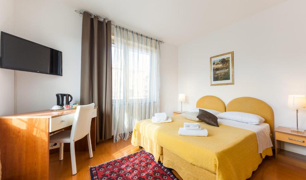 a hotel room with two beds and a desk at Casa vacanze Le Terrazze in Verona
