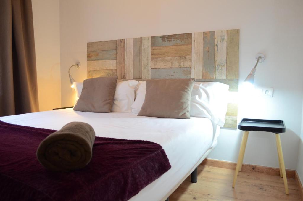 バルセロナにあるPoble Sec Apartmentsのベッドルーム1室(大型ベッド1台、木製ヘッドボード付)