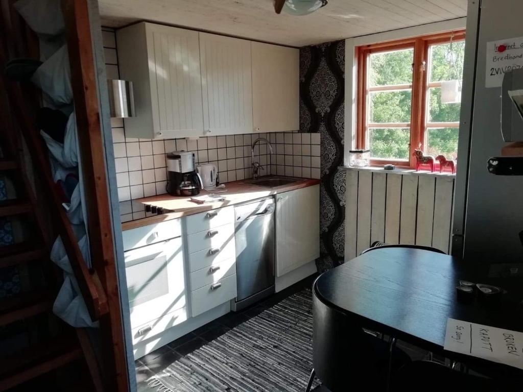 セルヴェスボリにあるYnde Private Apartmentの白いキャビネットとテーブル、窓付きのキッチン