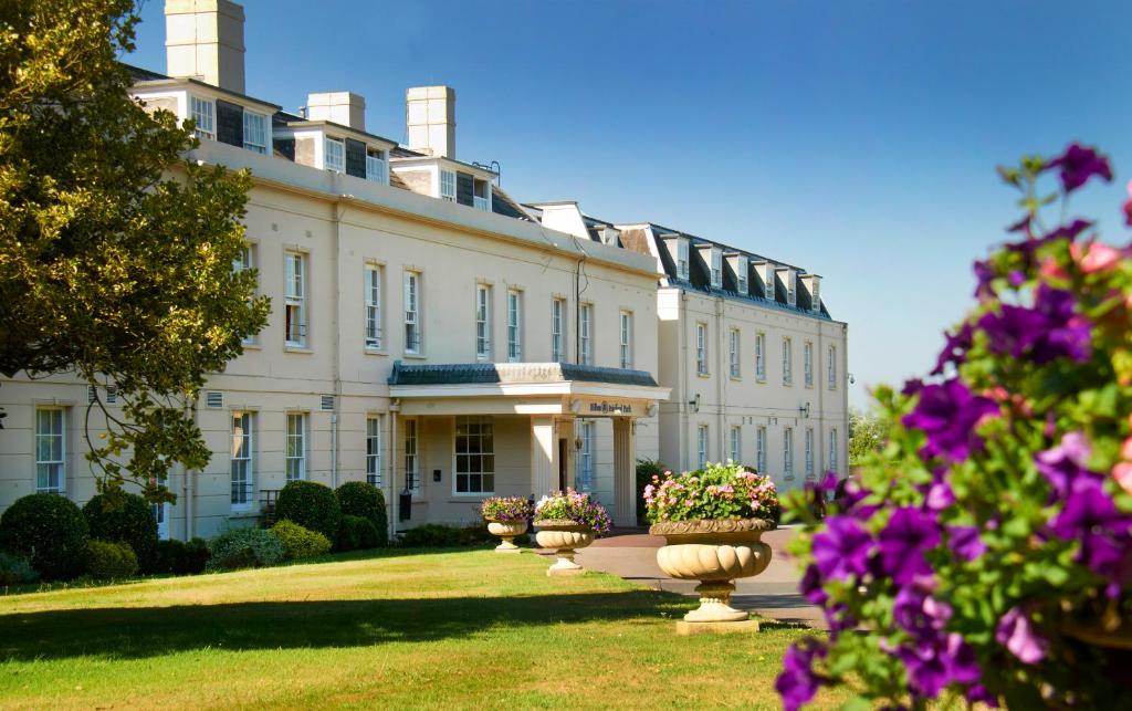 a large white building with flowers inront of it at Avisford Park Hotel in Arundel