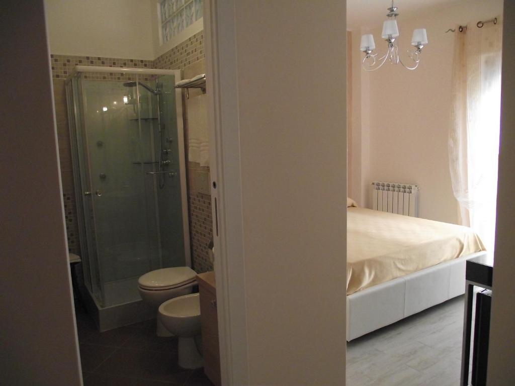 a bathroom with a shower and a toilet and a bed at B&B Il Mare degli Dei in Letojanni